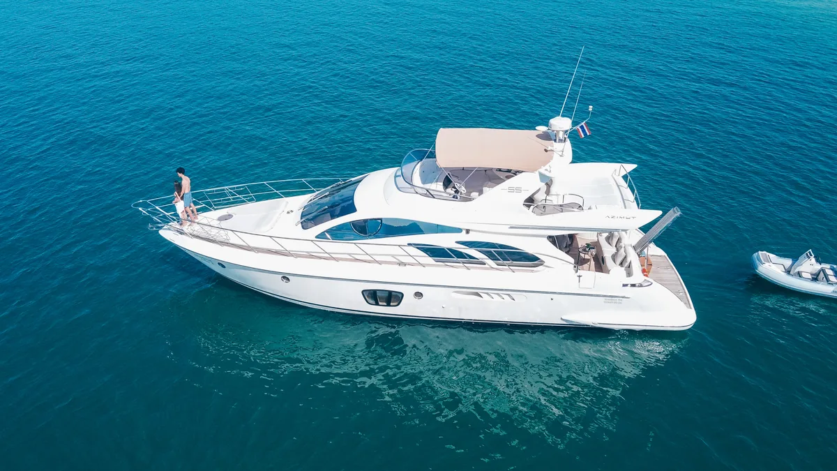 Azimut 55 After 8 — aerial view at anchor with a guest on the foredeck and tender alongside