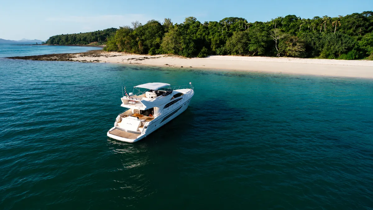 Riva 70 Aria Blue — at anchor off a white sand beach