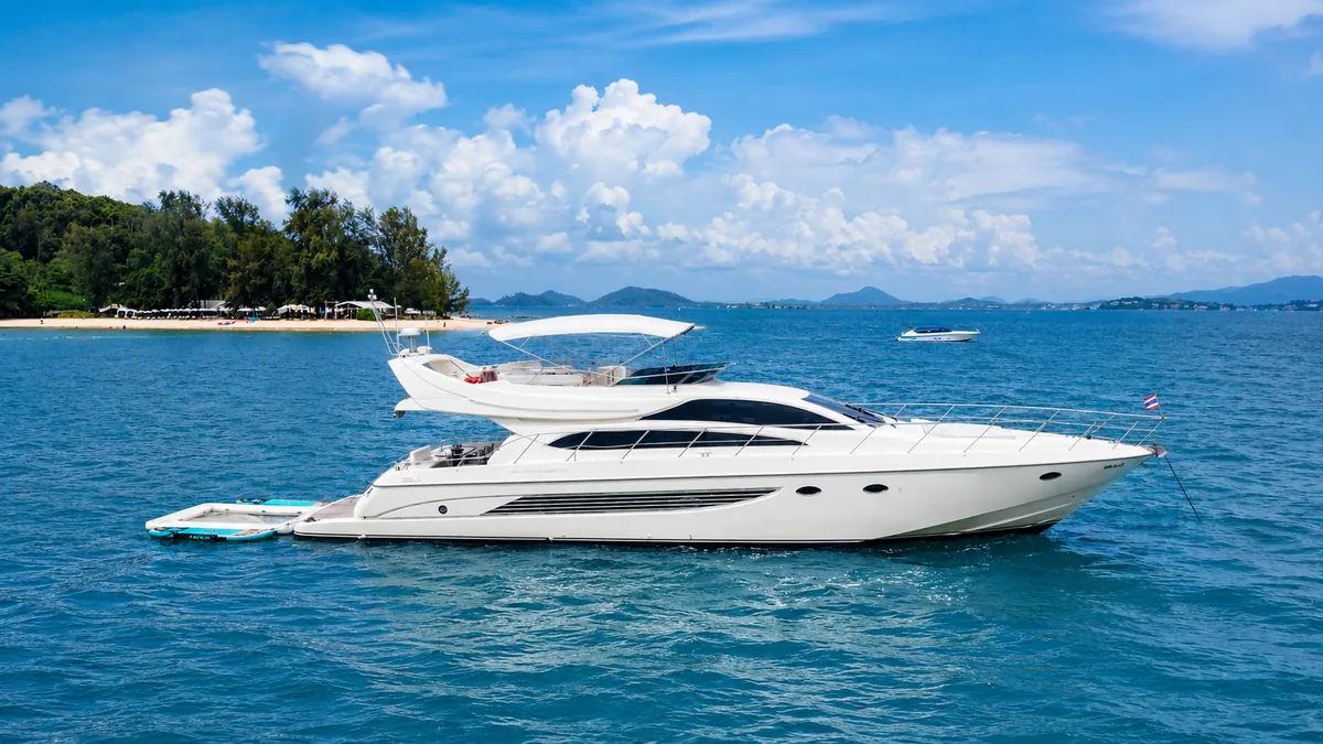 Riva 70 Aria Blue — profile view at anchor in turquoise water