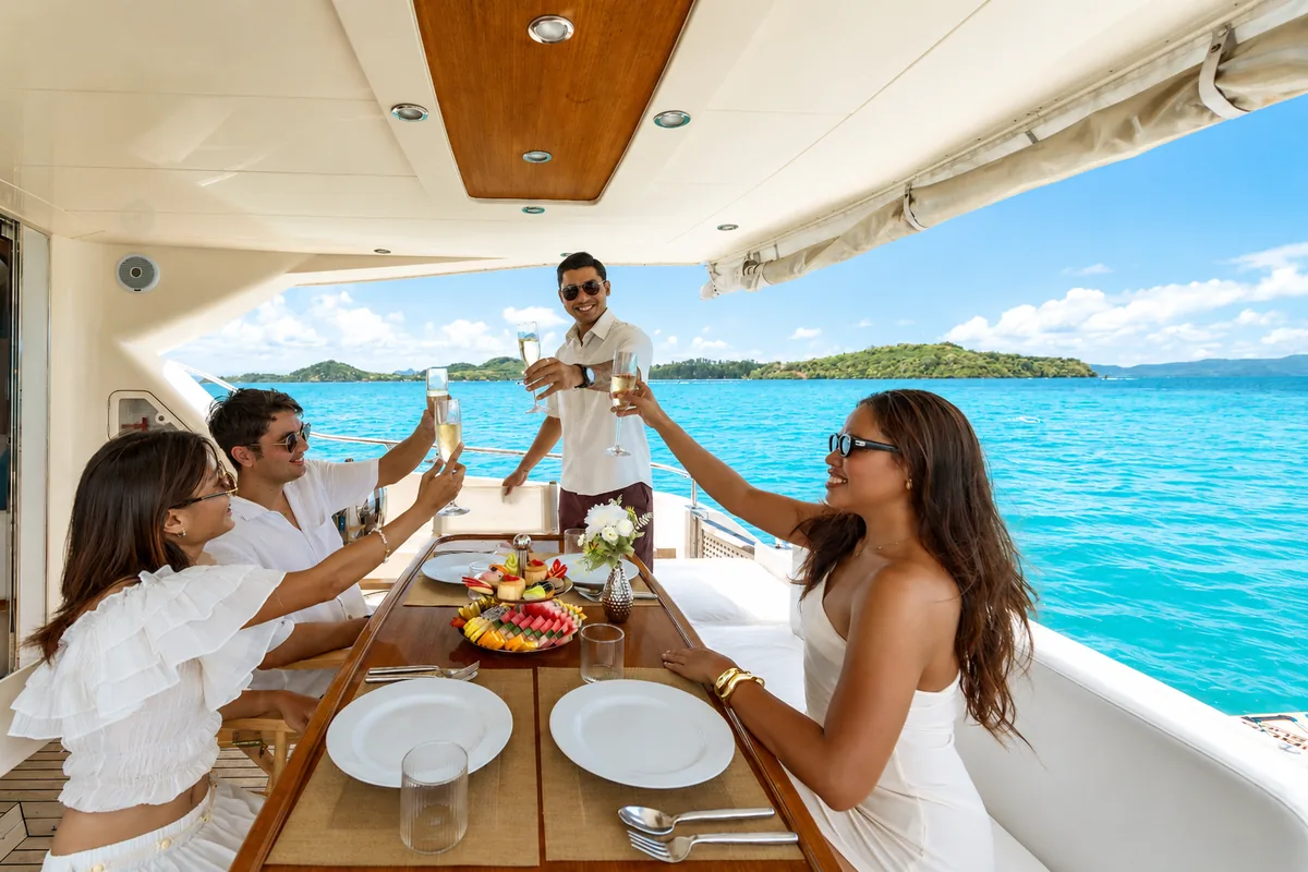 Riva 70 Aria Blue — guests toasting on the aft deck