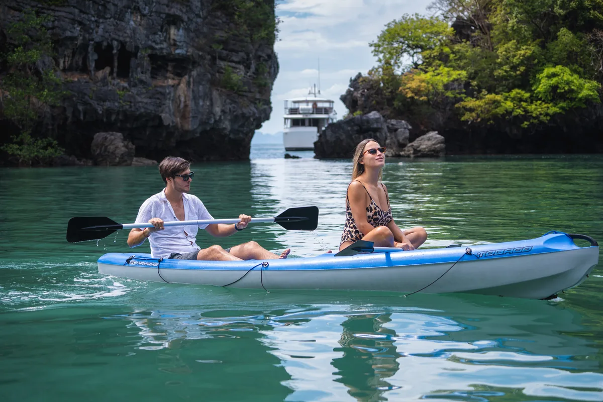 Siam Princess 70 — guests kayaking beside the yacht in a hong lagoon