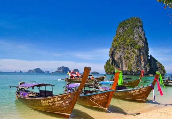 Longtail boats below the limestone cliffs at Railay, Krabi